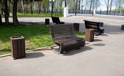 明媚的春日，城市公园里的棕色木长凳