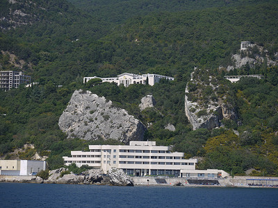 山脚下的大岩石巨石及其位于海边的酒店
