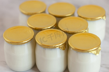 牛奶玻璃壶摄影照片_天然全脂牛奶工业酸奶，玻璃罐