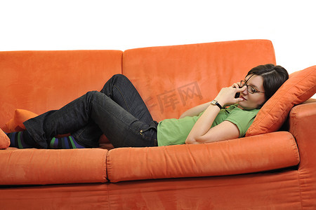 快乐的年轻女人在橙色沙发上放松