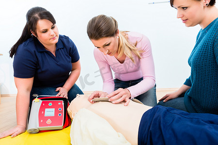 急救班学员学习如何使用除颤器