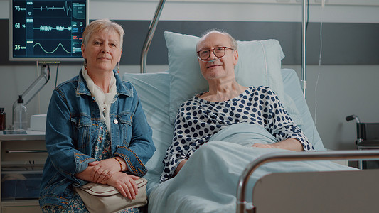 坐在医院病房的老年患者和妻子的肖像