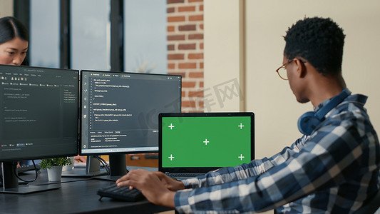 软件开发人员使用带有绿屏色度键模型的计算机键盘和笔记本电脑编写代码