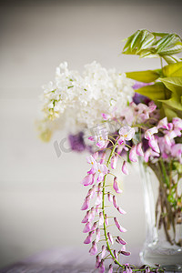 紫藤花卉摄影照片_美丽的春天花束，花瓶里有春丁香和紫藤