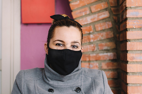 一名年轻女子脸上戴着外科口罩抵御 SARS-cov-2 的特写。