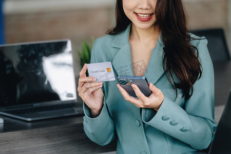 网上购物和网络支付，美丽的亚洲女性正在使用信用卡和手机在数字世界中网上购物或办事。