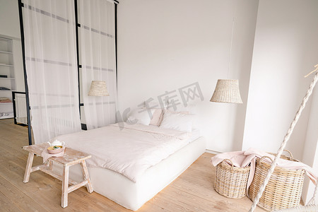 简约风格的淡粉色卧室配有一张双人床，并设有晾衣区和睡眠区