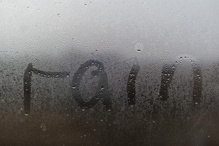 雾天温馨提示摄影照片_汗湿雾气的车窗上写着“雨”字。