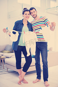 年轻夫妇在家抱着婴儿紧身衣