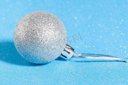 白色发光的圆摄影照片_闪闪发光的蓝色背景上的银色闪亮圣诞球