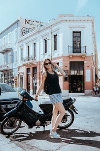 美丽的女孩沿着希腊首都雅典一个古老的欧洲小镇的街道行走。