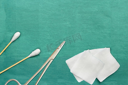 纱布和棉签棉巴士粘在绿色医用手术服上，并有复印空间