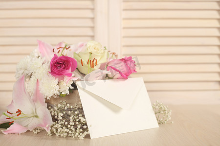 白色鲜花束摄影照片_鲜花篮和信封