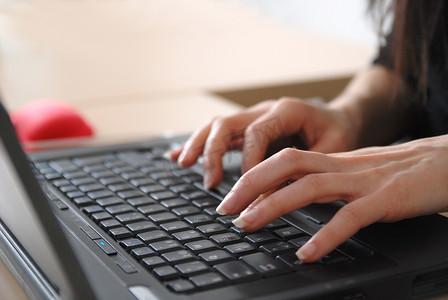 键盘女孩摄影照片_女人的手在笔记本电脑键盘上打字