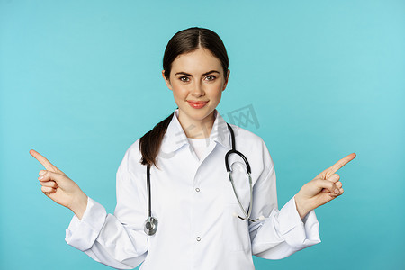 宣传医学摄影照片_热情的女医生，穿白大褂的医务人员，指着西德韦斯，左右，展示健康诊所宣传片，站在绿松石背景上