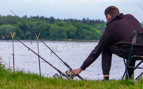 钓鱼竿轮的特写镜头，一个男人正在钓鱼。