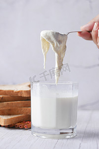 乳汁摄影照片_桌上放着一杯全脂牛奶，奶油牛奶。