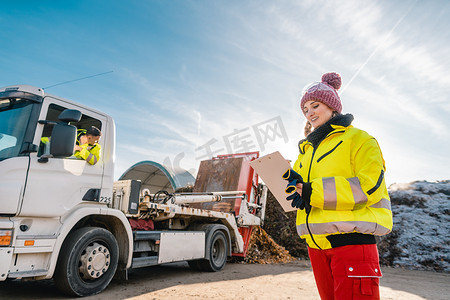 废品厂摄影照片_经理在堆肥厂登记卡车卸载生物质
