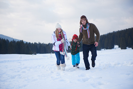 冬天幸福的一家人一起在雪地里玩耍