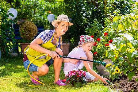 母亲和孩子在花园里浇花