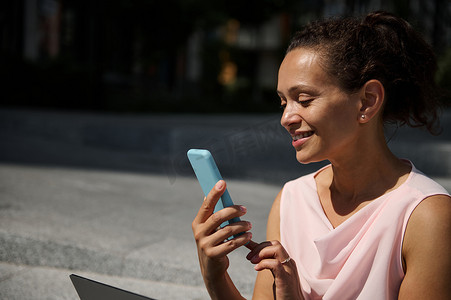 屏幕滑动摄影照片_美丽微笑的非洲裔美国女人在智能手机上滑动。