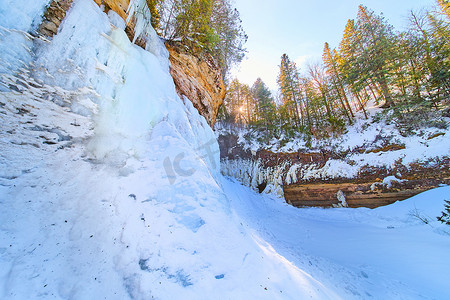 悬崖上树木冰冻瀑布的冰雪
