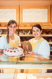 面包店的销售妇女有蛋糕和面包