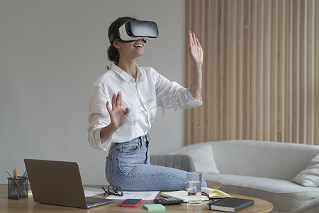身着优雅正装的女商人坐在办公室，在工作中使用 VR 技术