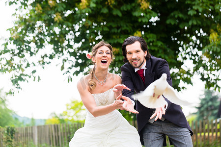 结婚新人摄影照片_婚礼上一对新人与飞翔的白鸽