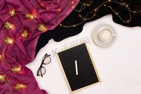 一杯咖啡、一块黑色小木板和一支写有新年目标的白色粉笔。