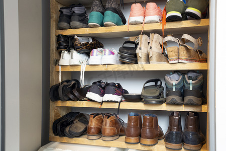 鞋架上收藏不同的鞋子，用于存放、杂乱和需要整理，衣柜内有架子，室内设计时尚装饰