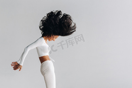 运动馆背景摄影照片_一位身穿白色运动服的女士正在瑜伽馆进行动态卡利冥想