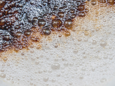 咖啡杯中柔软的白色牛奶泡沫和撒在上面的深棕色咖啡粉