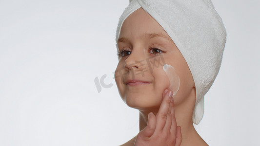 乳护肤摄影照片_可爱的小女孩应用清洁保湿面霜护肤天然奶油化妆品