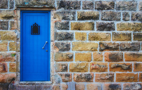 梦幻门摄影照片_粗糙的大石墙正面的蓝色门