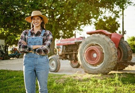 农场、农业和拖拉机，一位年轻的女农民站在外面的农业产业中。