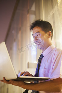 年轻的商人在户外使用他的笔记本电脑
