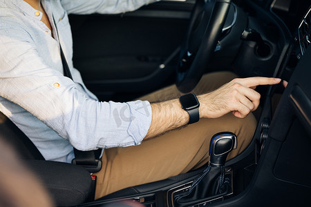 在现代豪华汽车的屏幕显示器上，无法辨认的男子手触摸、点击、敲击、滑动、拖动和滑动。
