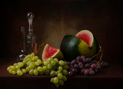 静物画，切好的西瓜，上面有不同品种的绿色和黑色葡萄，桌子上有几个装饰瓶，背景是深色