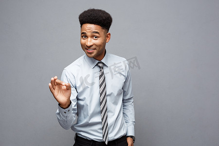 商业理念-自信开朗的年轻非洲裔美国人在他面前表现出良好的手指，在灰色背景下表现出令人惊讶的表情。