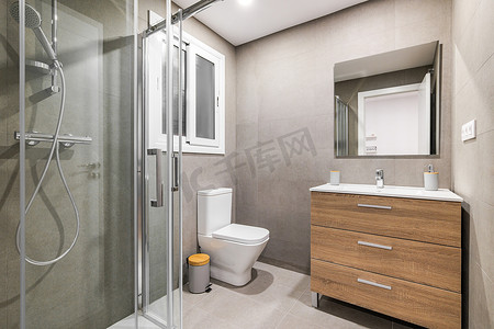 现代翻新浴室配有淋浴区、卫生间、带白色水槽和镜子的木质底座。