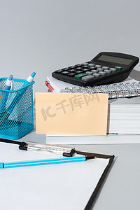 重要信息显示在桌子上的笔记上，周围有铅笔、书籍、剪贴板和计算器。