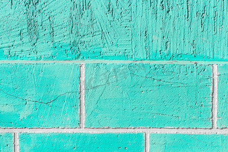 砖块墙上的海蓝宝石或天蓝色油漆，有破裂的纹理背景