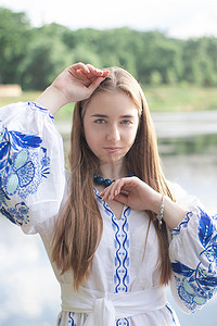 穿着蓝色民族传统刺绣衬衫的年轻女子的肖像。