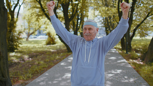 运动高级运动员祖父训练跑步，庆祝完成成功比赛赢得胜利
