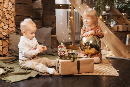 圣诞节前夕，弟弟和妹妹在一栋为新年假期装饰的漂亮房子里玩耍。
