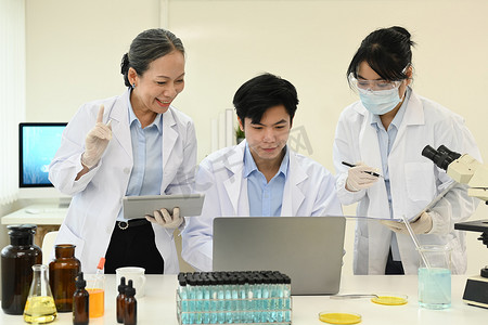 专业科学家团队查看笔记本电脑屏幕，收集数据并总结科学报告的信息