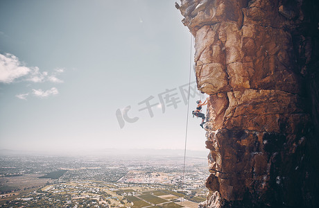 山地、攀岩和运动，一名女运动员和登山者在大自然的山坡上沿绳下降。