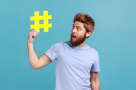 男子手持黄色标签符号，使重要话题流行，在互联网上引领趋势。