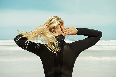 扎头发头发摄影照片_冲浪时将头发扎在脑后以求舒适。
